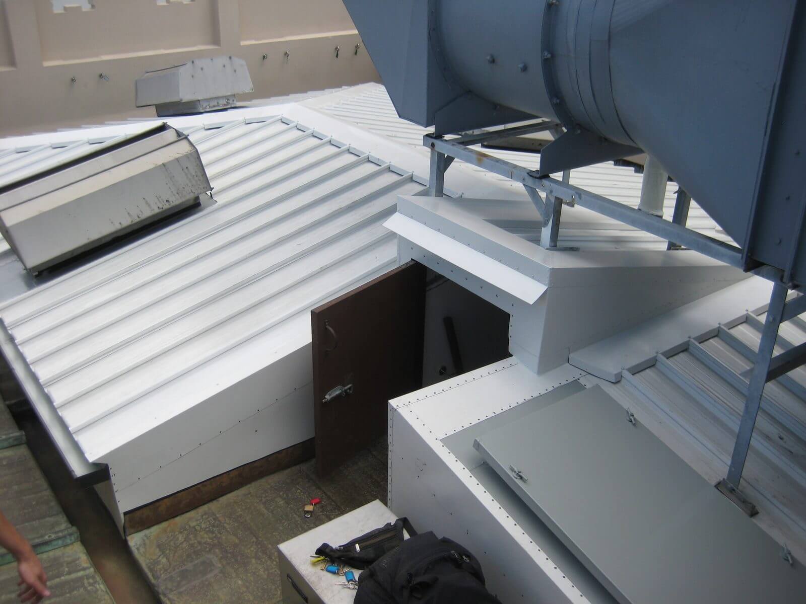 Finished custom white metal roof with flashing around plant equipment