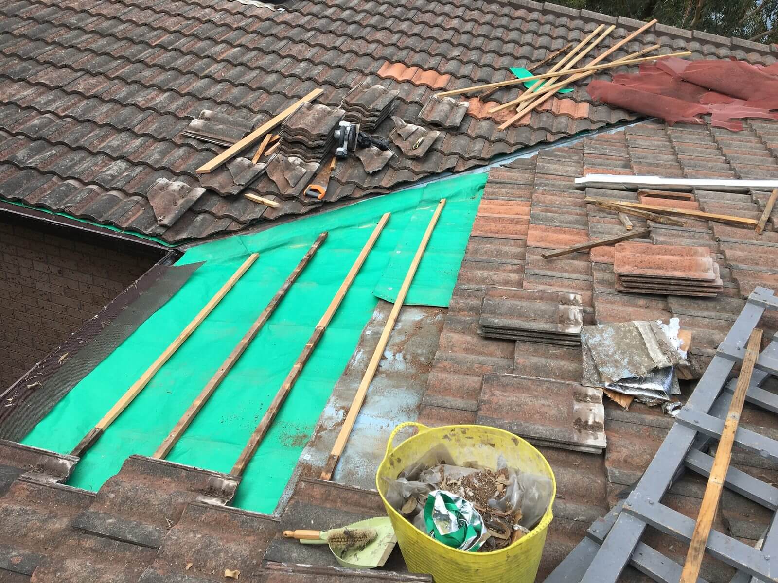 Tiled roof under repair with new sarking, battens and replacement tiles